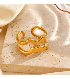 Detail of gold-plated double-layer wavy ring with molten lava texture on stone surface