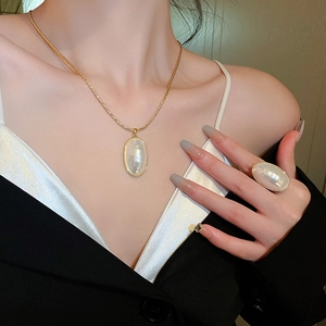 Gros plan d'un collier de perles ovales plaqué or avec bague assortie sur un mannequin