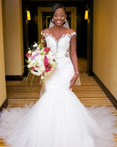 Close-up of off-shoulder lace neckline and floral embroidery on white mermaid bridal gown
