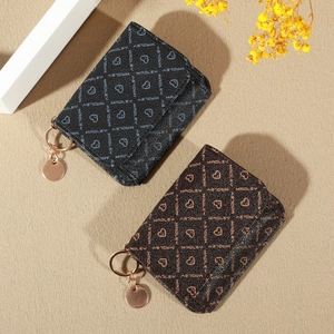 Detailed close-up of brown and black leather wallets featuring heart and letter patterns