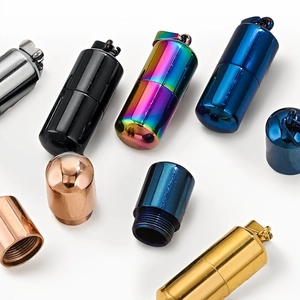 Polished stainless steel pill capsule pendants in multiple metallic colors on white background