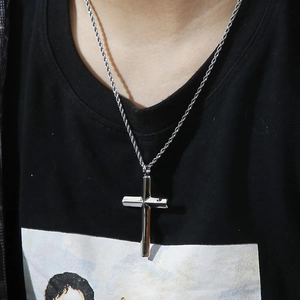 Polished silver stainless steel cross pendant on twist chain worn by male model