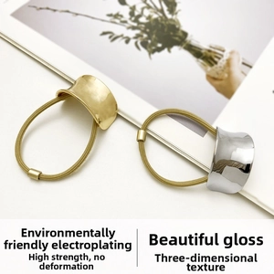 Detailed close-up of gold and silver metallic ponytail holders on a white card