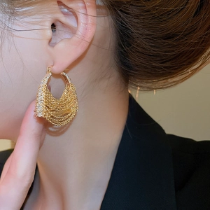 Detailed view of 18k gold plated hoop earrings with zircon fringe chains on model ear