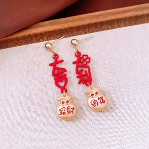 Detail of Chinese style tassel earrings with red lucky bag pendants and gold accents