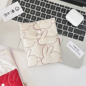 Macro shot of quilted bunny pattern storage pouch with button closure on a laptop keyboard