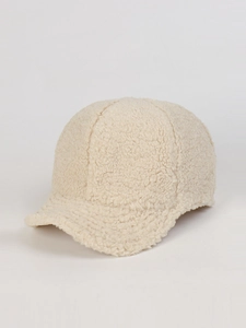 Dettaglio della texture in pile di agnello beige di un berretto invernale caldo