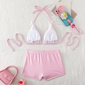 Detail of pink plaid bikini set with halter top, white bow accent and high waist shorts