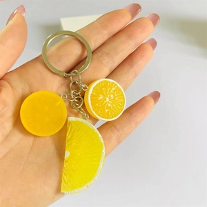 Dettaglio di ciondoli a fette di limone in resina con anello metallico su un portachiavi