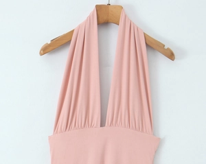Détail de robe dos nu rose avec décolleté en V profond et plis à la taille ajustée