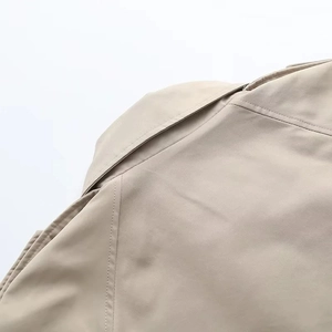 Gros plan de l'épaule d'un trench-coat kaki avec détails de couture précis