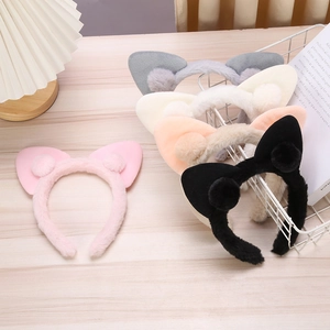 Detailed view of plush cat ear headbands in pink, grey, beige, orange and black colors