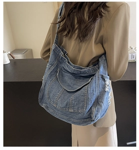 Gros plan détaillé sur la texture en denim usé et les détails effilochés du sac cabas