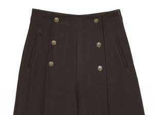 Dettaglio degli shorts a vita alta marrone cioccolato con sei bottoni dorati vintage