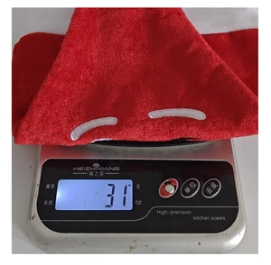 Detail showing red velvet Christmas hat weight measurement of 31g on a digital scale