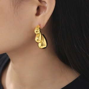 Bohemian 18K gold plated tiered waterdrop earrings with a polished mirror finish on model