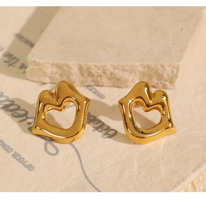 Detailed view of gold-plated 18k stainless steel lip-shaped earrings on a vintage paper