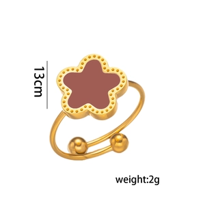 Detailed macro view of golden five-leaf clover ring with red inlay and beaded edges