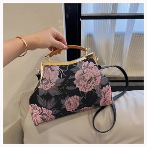 Detail of vintage black embroidery handbag with pink flowers and wooden handle