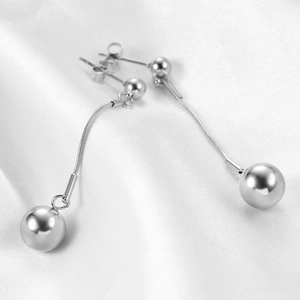 Minimalist 18K silver ball drop earrings with long snake chain on white silk fabric