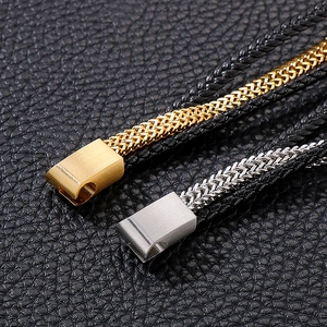 Macro shot of multi-layer braided leather bracelet with gold and silver steel clasps