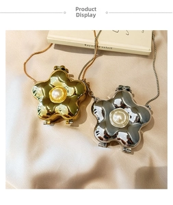 Detail of mini flower-shaped acrylic purses in gold and silver with pearl accents