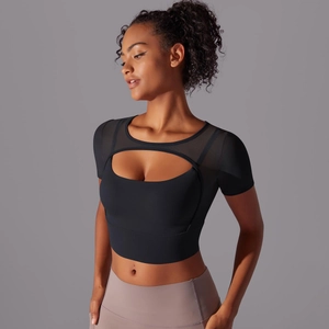 Detail of black sports top featuring sheer mesh panels and oval cutout design