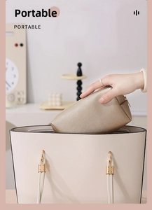 Champagne gold PU leather makeup bag being placed into a large tote for travel storage