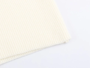 Detailaufnahme des cremefarbenen Rippstrick-Stoffs zeigt die feine Textur und Qualität