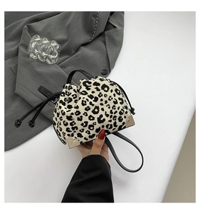 Close-up of leopard print bucket bag with metal corner protectors and drawstring closure