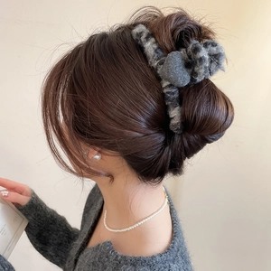 Détail d'une grande pince à cheveux en peluche à motif léopard gris pour coiffures chignons