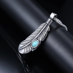 Detailed shot of silver feather pendant with blue oval turquoise on a box chain