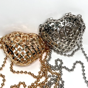 Close-up of gold and silver heart-shaped metal hollow woven evening clutch bags