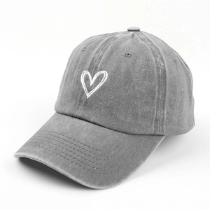 Detail of washed grey cotton baseball cap with white heart embroidery and worn texture