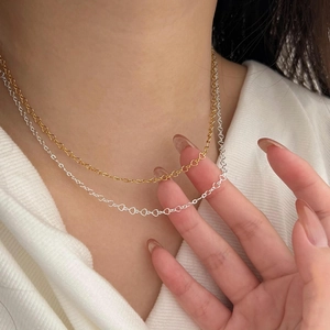 Close-up of minimalist S925 sterling silver heart-shaped chain necklaces in gold and silver
