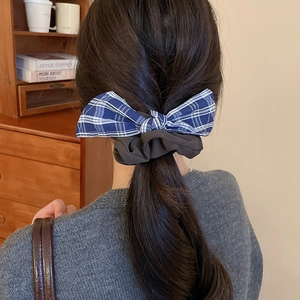 Detail of blue plaid fabric bow scrunchie styled in hair with a high-quality aesthetic
