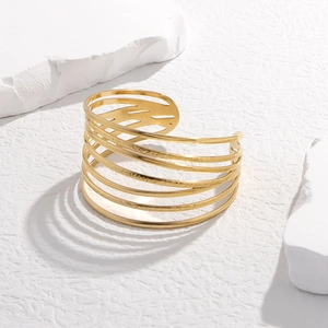 Macro detail of gold multi-layer open cuff bracelet with hammered texture and minimalist design