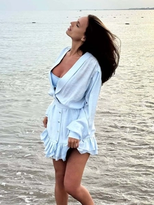 Detailed view of the layered ruffle hem on this light blue V-neck long sleeve dress