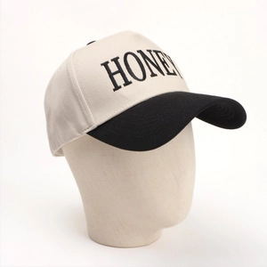 Close-up of embroidered HONEY letters on a contrast color baseball cap with stitching