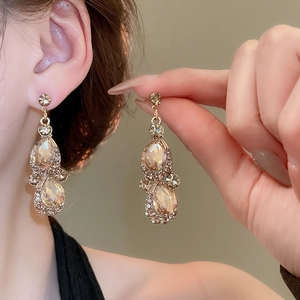 Detail shot of vintage teardrop earrings with champagne crystals in a gold setting