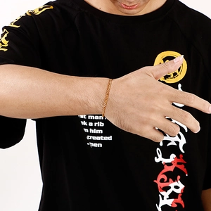 Close-up of a gold stainless steel flat Cuban link bracelet worn on a man wrist