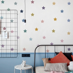 Vibrant multi-colored star wall decals applied to a modern bedroom wall for decoration