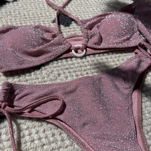 Close-up of pink glitter bikini with silver shimmer fabric and ring detail