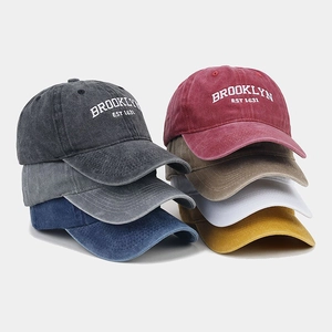 Stacked collection of washed cotton baseball caps in multiple colors with Brooklyn embroidery