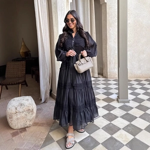 Elegante abito lungo nero in pizzo crochet con maniche lunghe e gonna a balze multistrato