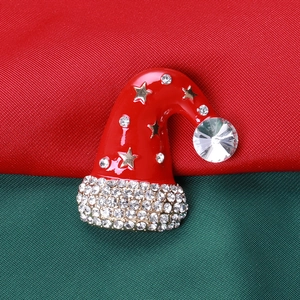Macro d'une broche bonnet de Noël rouge avec strass sur un fond festif thématique