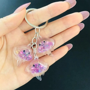 Detailed close-up of pink translucent jellyfish keychains with glitter and gold foil