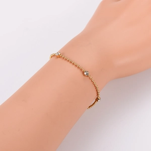 Elegant gold beaded chain bracelet with three sparkling rhinestones on a wrist model