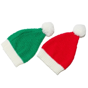 Set di cappelli di Babbo Natale in maglia rossa e verde con pompon bianchi su sfondo bianco