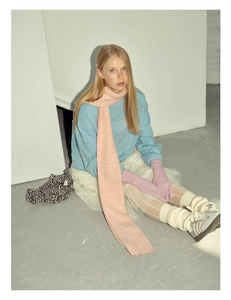 Close-up of pink wool blend knitted scarf texture worn in a winter fashion style